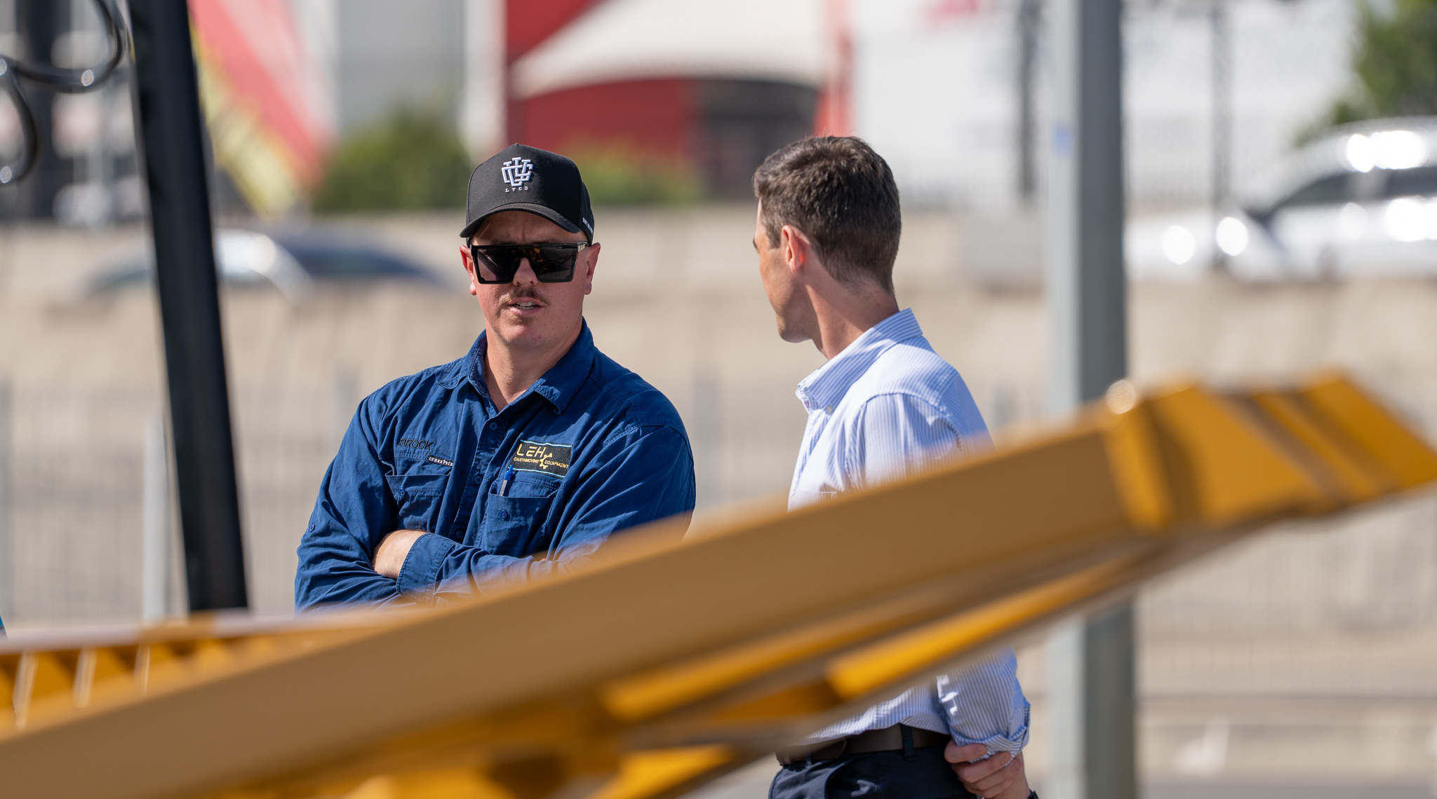 Brock Harvey speaking with James Allan beside a LEH bulldozer