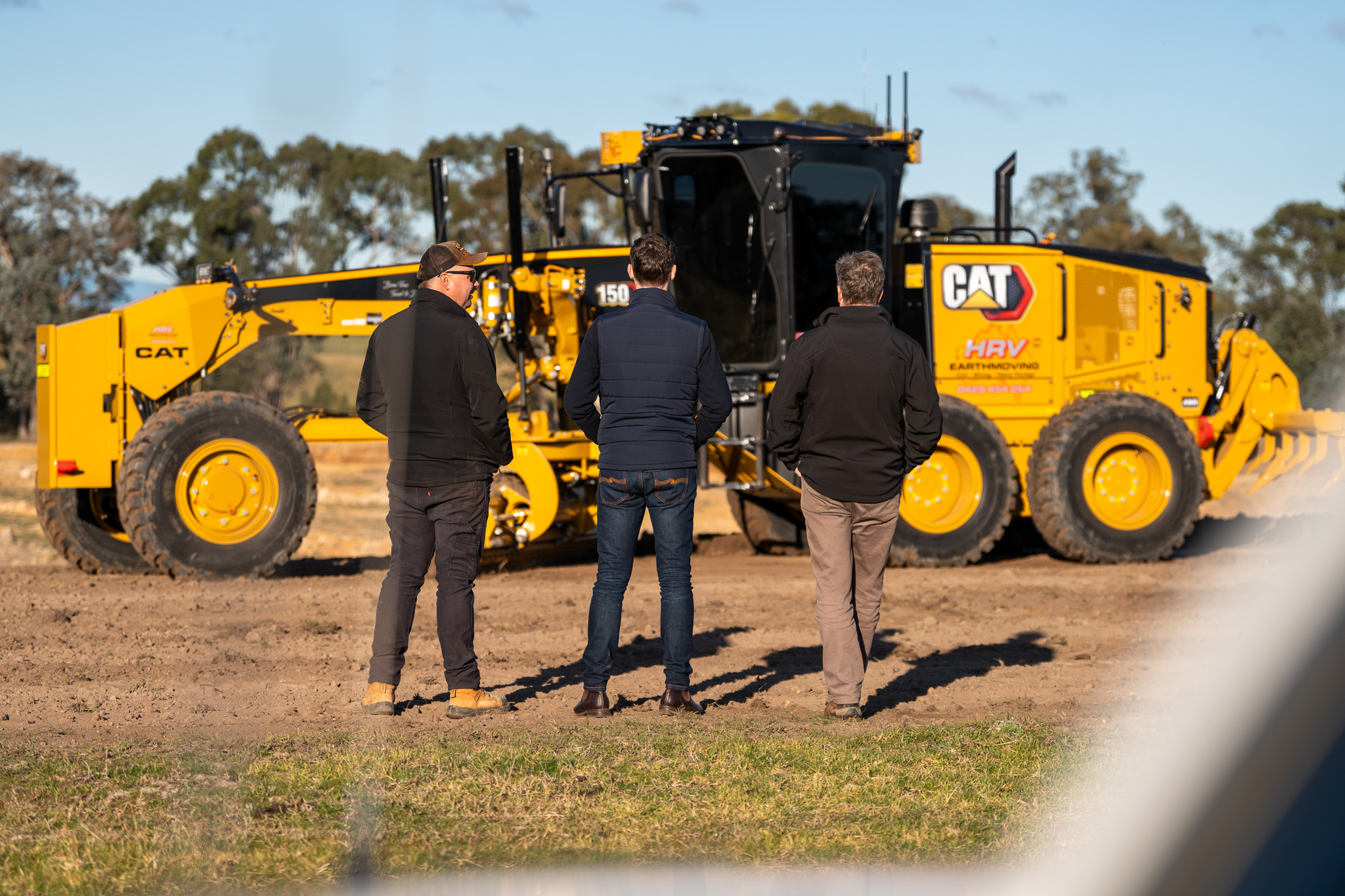 HRV team and equipment representatives inspecting the Caterpillar grader